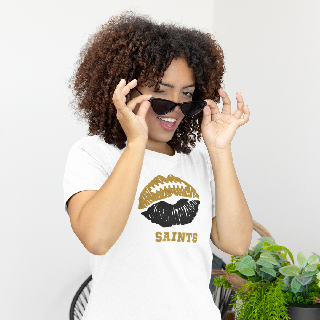 A woman wearing a white t-shirt with a red and black lips football graphic and the word Saints underneath