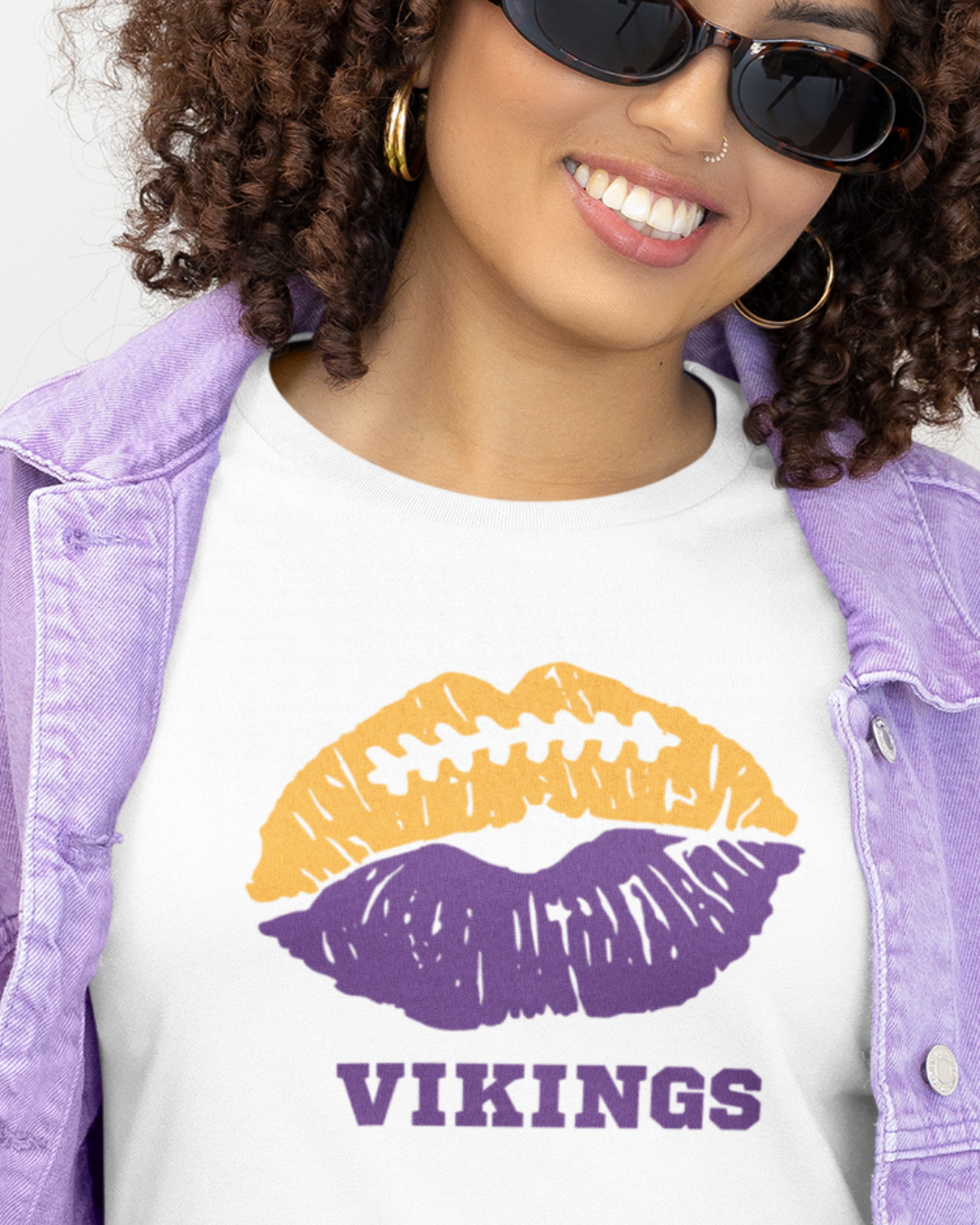 A woman wearing a white t-shirt with a lip-themed football design reading Vikings