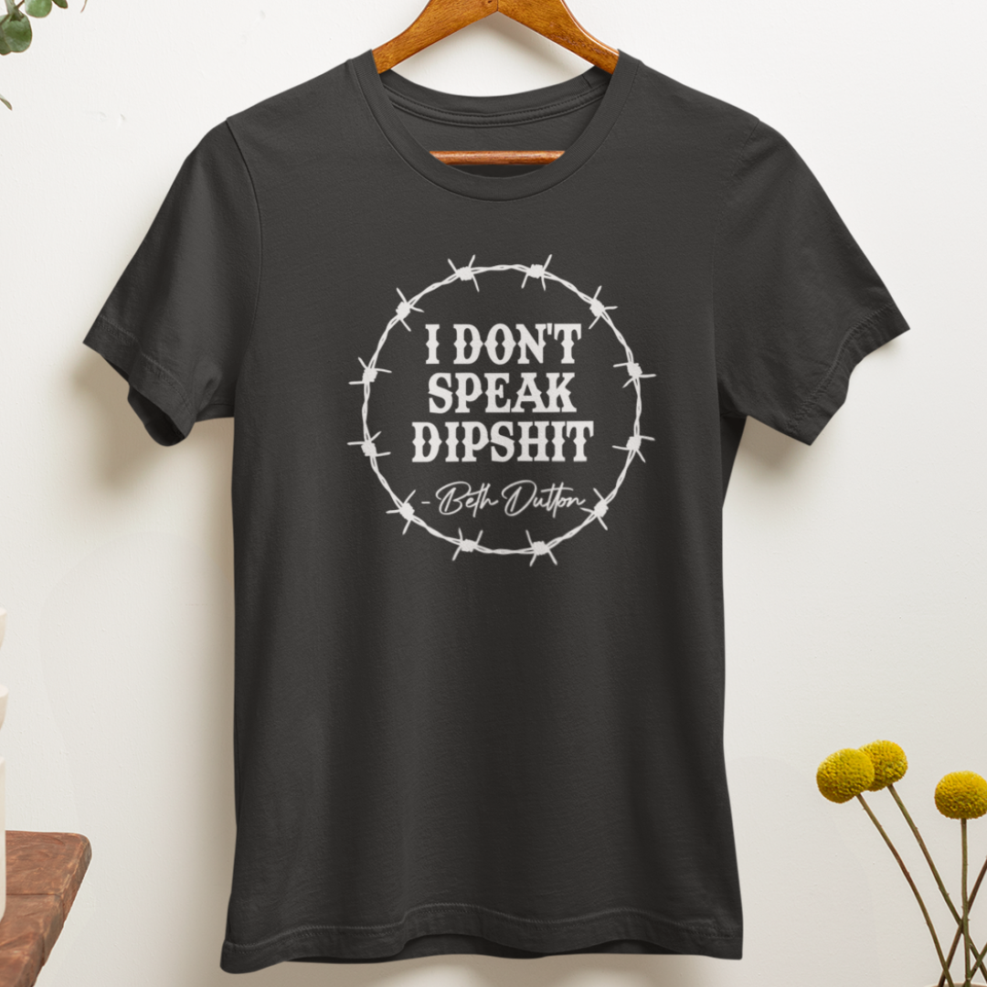Close up of a sarcastic western-inspired t-shirt in charcoal with bold white text reading, "I Don't Speak Dipshit".