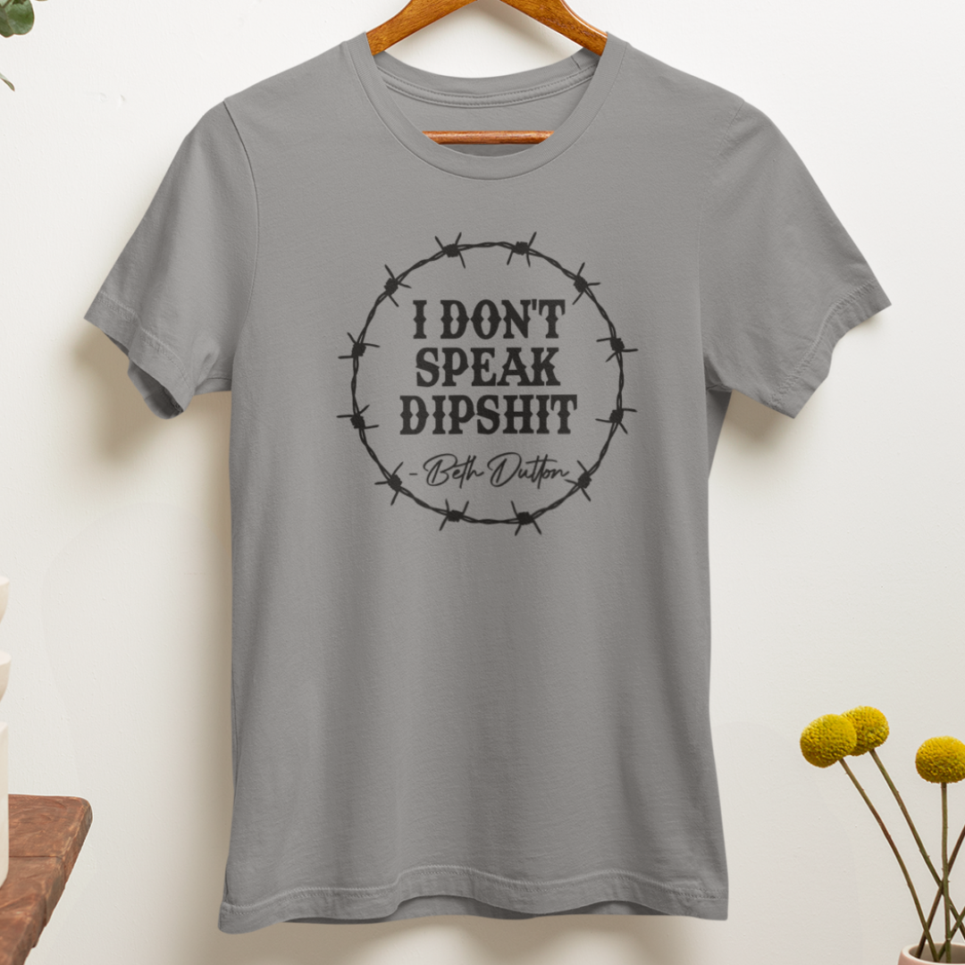 Close up of a sarcastic western-inspired t-shirt in grey with bold black text reading, "I Don't Speak Dipshit".
