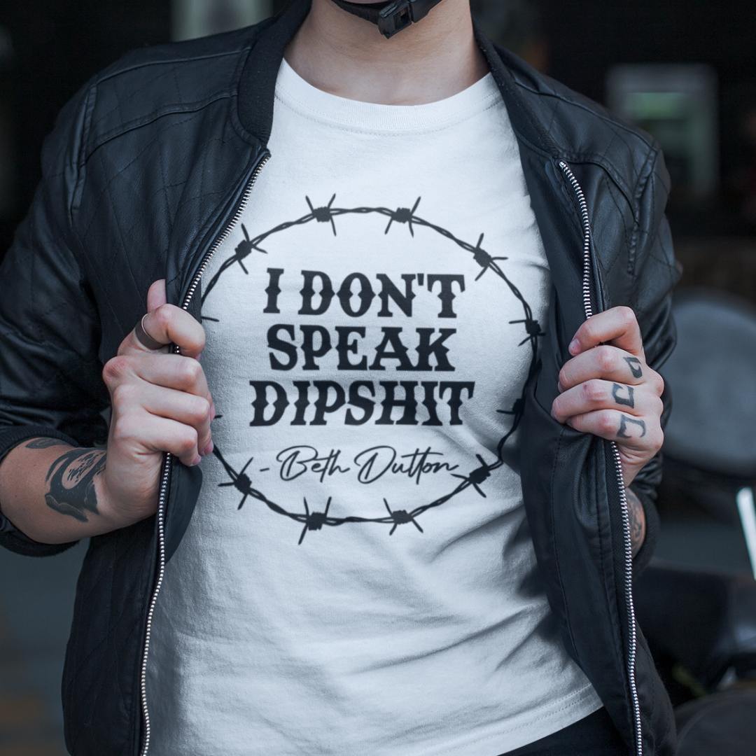 Close up of a woman wearing a sarcastic western inspired t-shirt in white with bold black text reading, "I Don't Speak Dipshit".